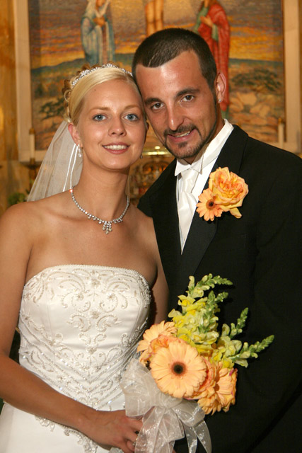 Bride and groom with bouquet of light peach gerbera daisies and yellow snap 